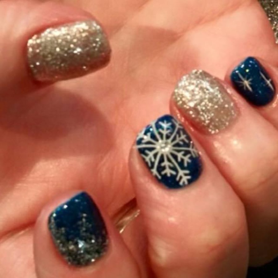 Navy and gold glitter snowflake winter nail art on a gel manicure in OKC