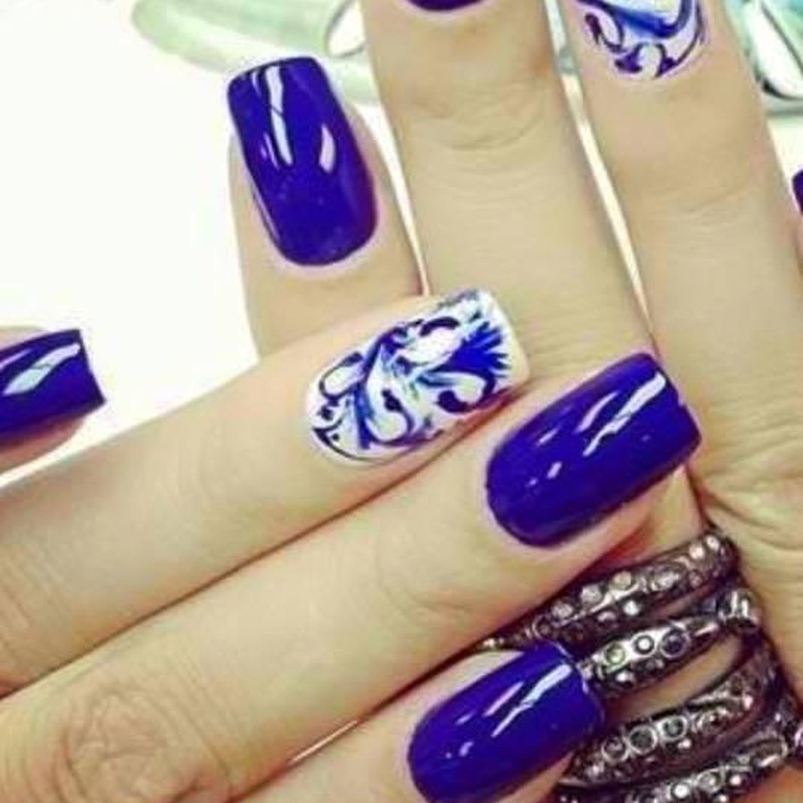 Cobalt blue acrylic nails with white floral hand-painted nail art near Nichols Hills